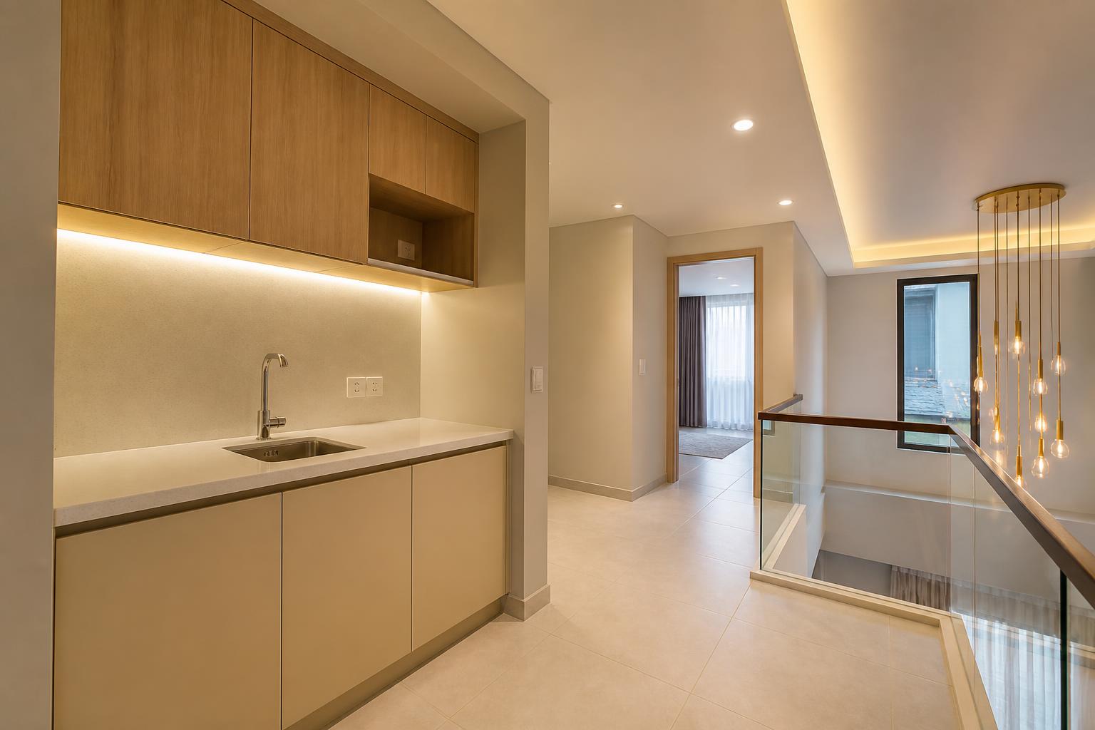 Built-in preparation pantry with a small sink, quartz counter, open lit niche and under-cabinet lighting
